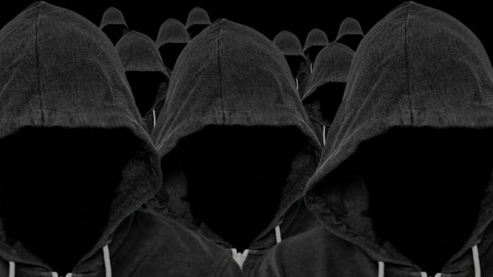 'The Com' Cyberattacks Support Violence & Sexploitation 2 Hooded crowd John Williams RF Alamy glCqeX